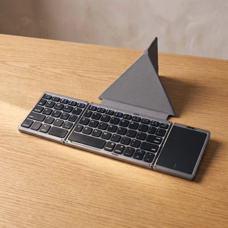The folding keyboard in Graphite with its case, on oak