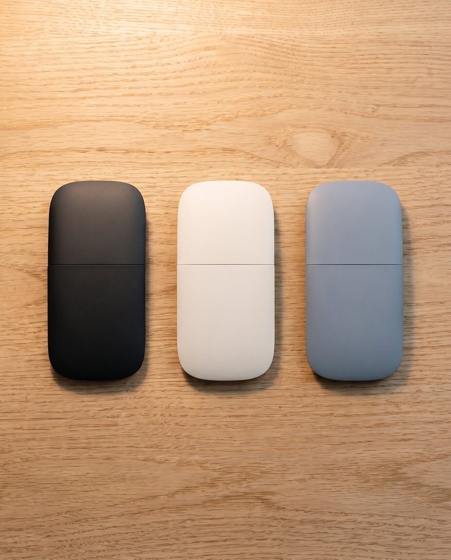 The folding mouse in Matte Black, Cloud White and Mist Blue, lying flat
