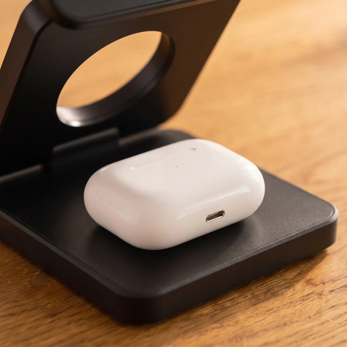 An earbuds case resting on the charging stand's base