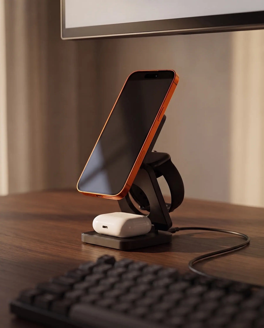 The charging stand on a modern desk beside a laptop, charging cable connected