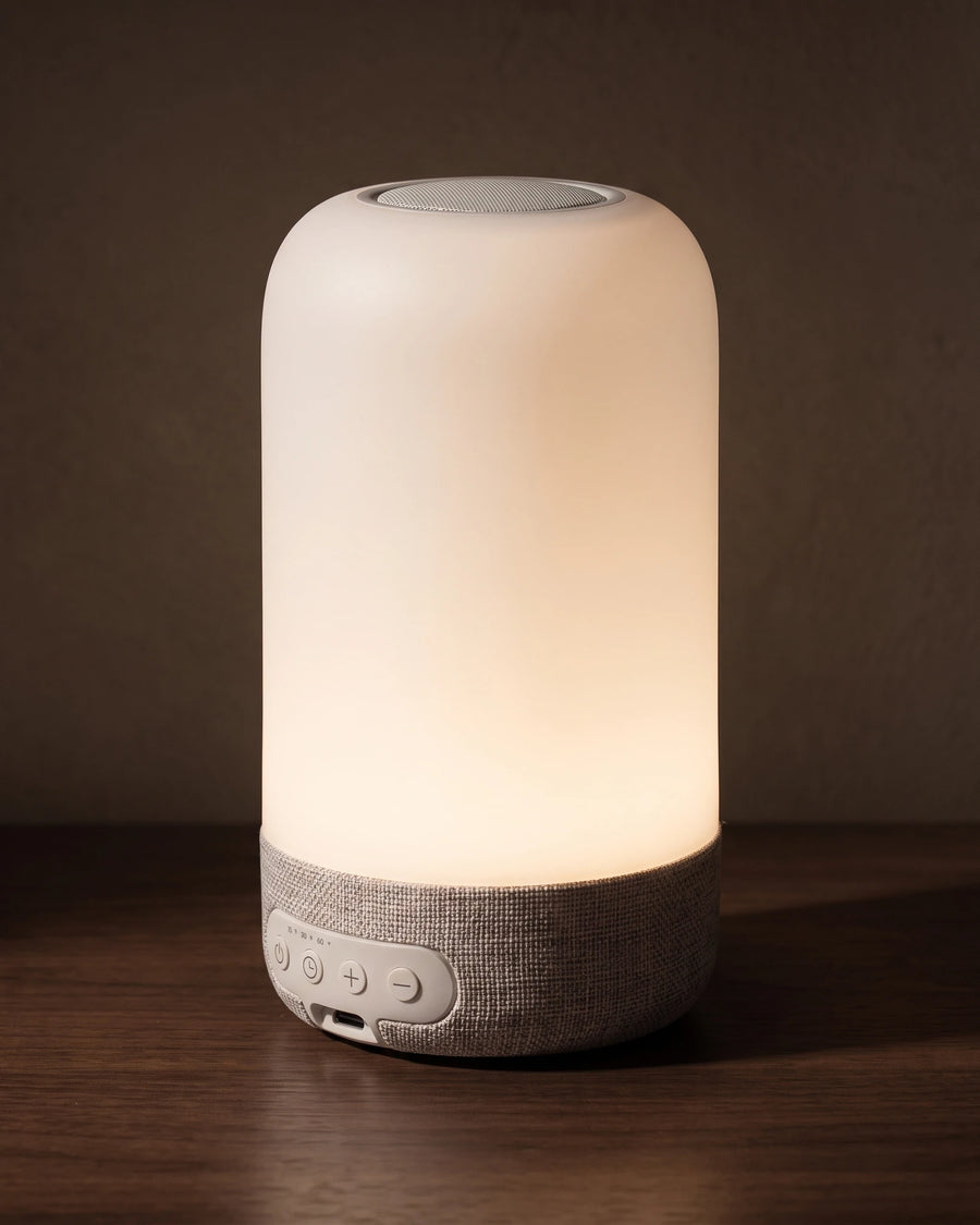 The bedside lamp — side profile, the height of a coffee mug