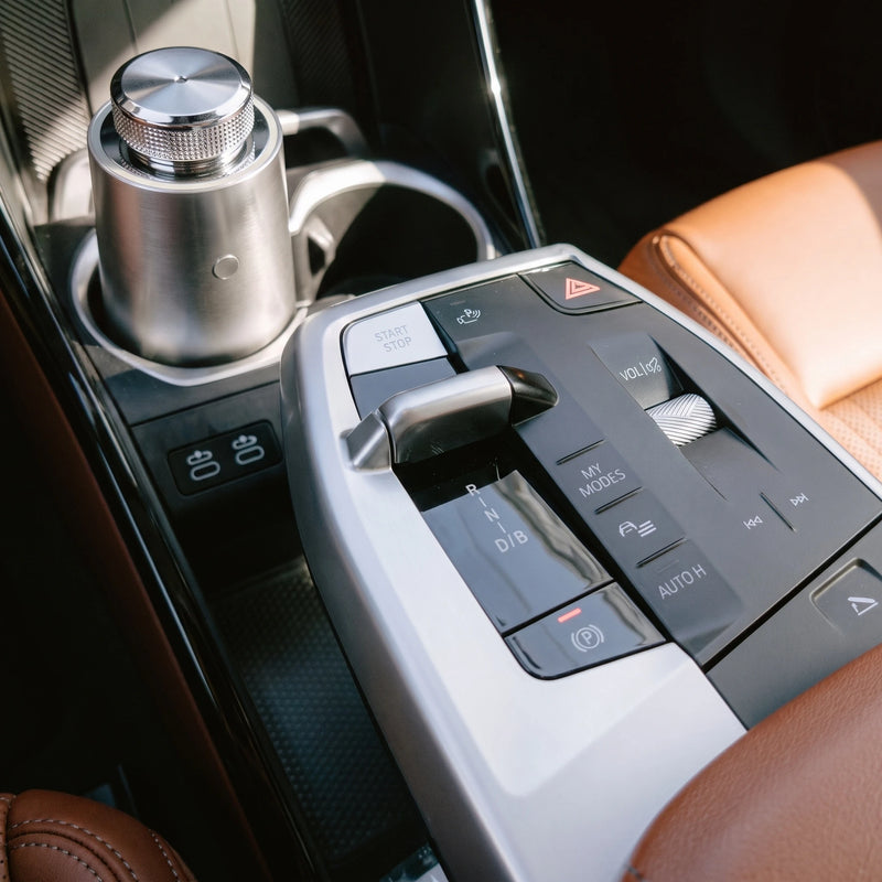 The car diffuser in Brushed Silver in the cup holder of a leather car console, no cable