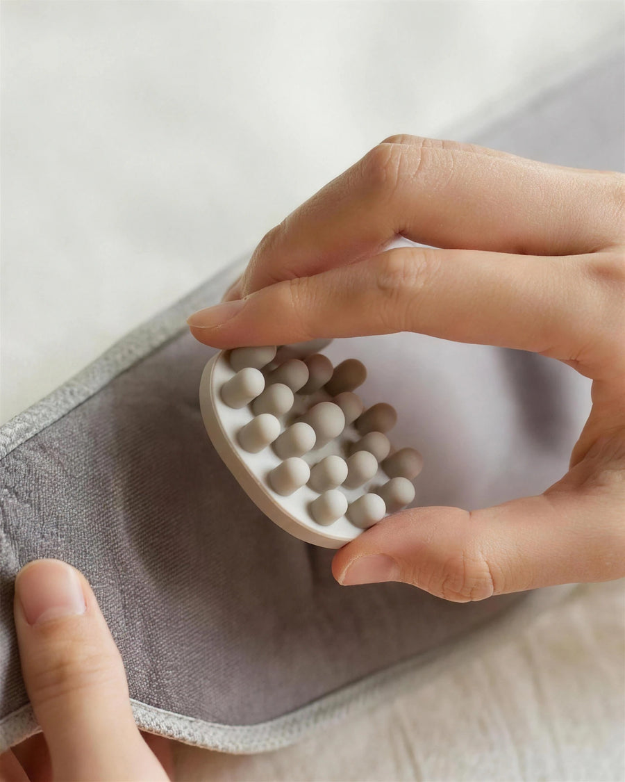 The heated eye massager — a bead pad lifted out of its socket, the side that touches the face