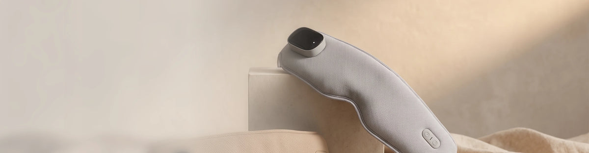 A heated eye mask resting on folded linen in warm afternoon light