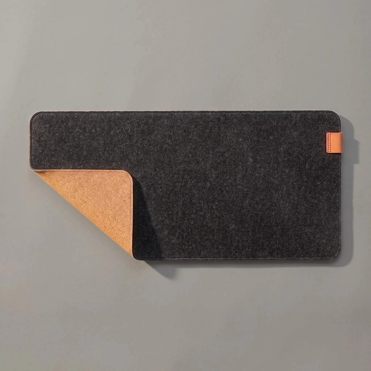 Felt & Cork Desk Mat in Charcoal, a corner turned back to show the cork underside