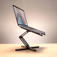 The folding laptop stand in Matte Black, holding a laptop at eye level