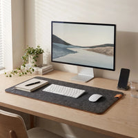 Felt & Cork Desk Mat in Charcoal on a home desk with a monitor, a keyboard, a mouse, a notebook and a plant
