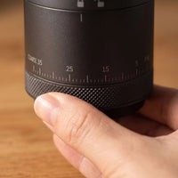 A hand mid-turn on the coarse-to-fine dial