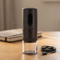 The cordless coffee grinder beside its USB-C charging cable