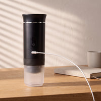 The portable espresso maker charging over USB